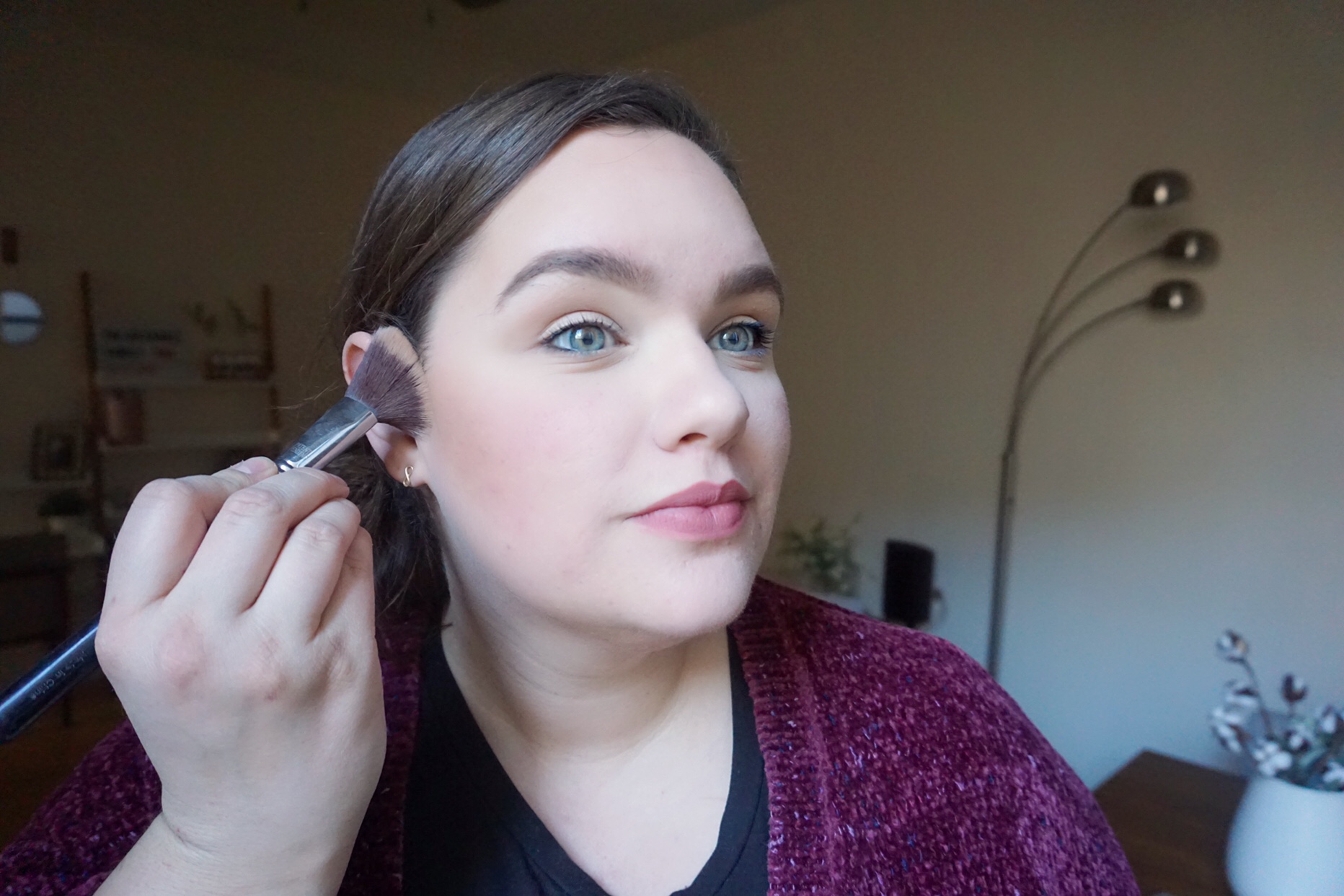 Applying bronzer underneath cheekbones 